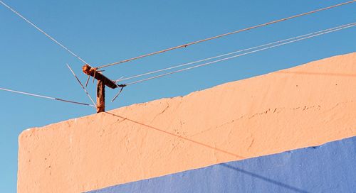 Low angle view of cables against clear blue sky