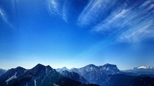 Scenic view of mountains against blue sky