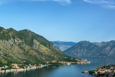 Scenic view of lake and mountains against blue sky