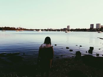 Rear view of woman looking at sea against clear sky