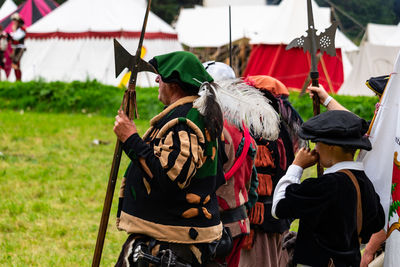 People in traditional clothes standing on field