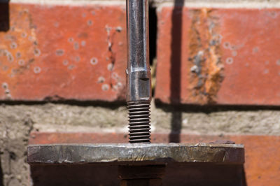 Cropped image of machinery against brick wall