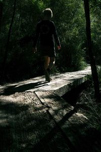 Rear view of woman walking in forest