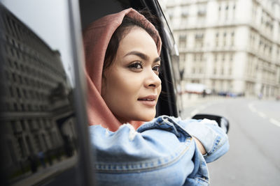 Uk, england, london, young woman wearing hijab looking out of a taxi