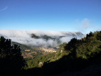 Smoke emitting from mountain against clear blue sky