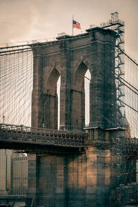 Low angle view of bridge against buildings in city