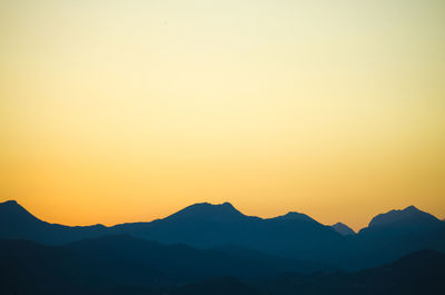 Silhouette of mountain range against sky at sunrise