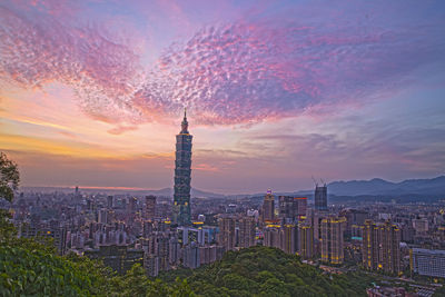 High angle view of city lit up at sunset