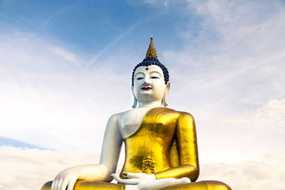 Low angle view of buddha statue against sky