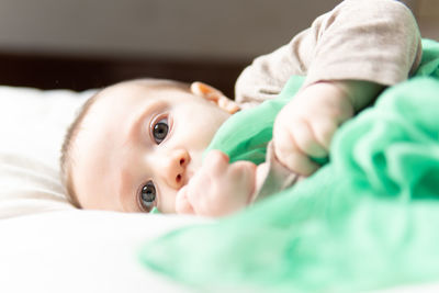 Portrait of cute baby lying on bed