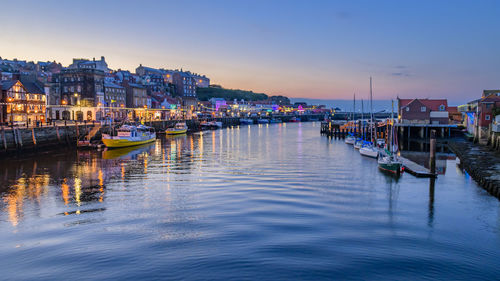 River esk flowing through whitby harbour in the evening showing reflections from the town