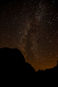 Scenic view of silhouette mountain against sky at night