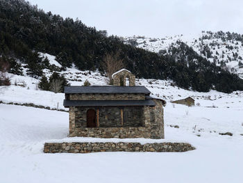 Built structure on snow covered field against sky