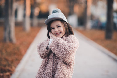 Happy girl in warm clothing at park