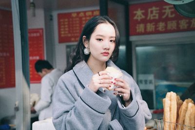 Young woman eating food at store