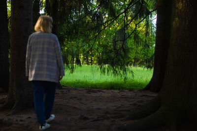 Rear view of woman walking in forest