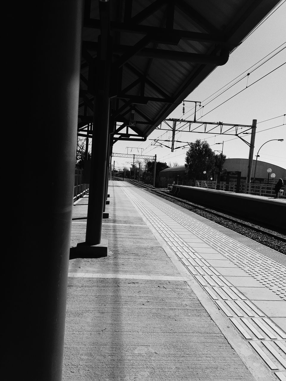 rail transportation, transportation, railroad track, railroad station platform, track, railroad station, public transportation, mode of transportation, architecture, built structure, day, nature, empty, no people, electricity, train, sky, travel, diminishing perspective, the way forward, outdoors, station, architectural column, platform, power supply, long