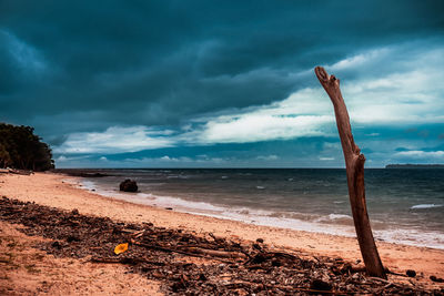 Scenic view of beach against storm clouds