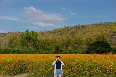 Rear view of woman standing in field