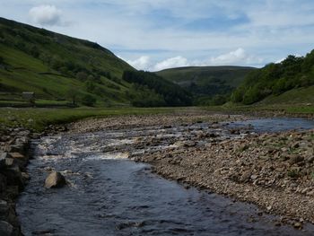 Scenic view of river amidst mountains against sky