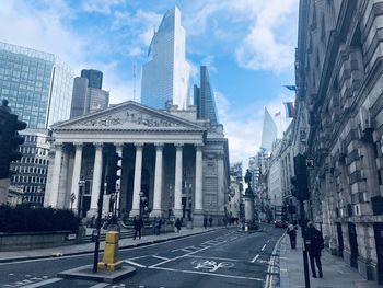 View of city buildings against cloudy sky