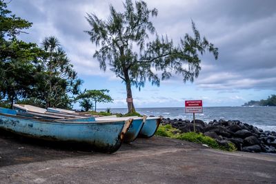 Boat moored on beach against sky