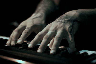 Cropped hands of man playing piano