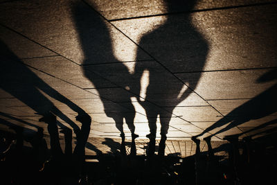 Shadow of people walking on footpath