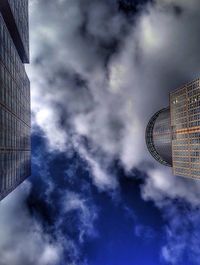 Low angle view of modern building against cloudy sky