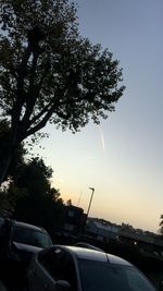 Cars on road against sky during sunset
