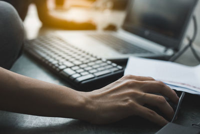 Midsection of man using laptop on table