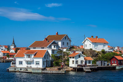 Buildings by town against blue sky