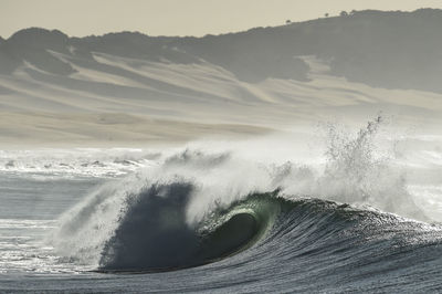 Waves splashing in sea during sunset