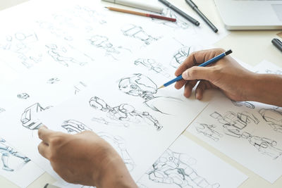 High angle view of man reading book on paper