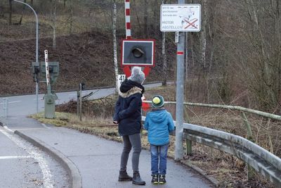 Rear view of people standing on road in winter