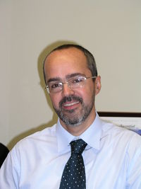 Portrait of smiling businessman against wall