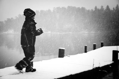 Boy on snow covered pier
