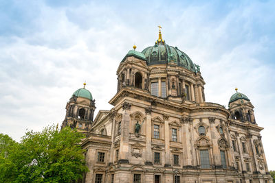 Low angle view of berlin cathedral against cloudy sky