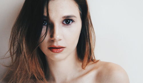 Close-up portrait of beautiful young woman over white background