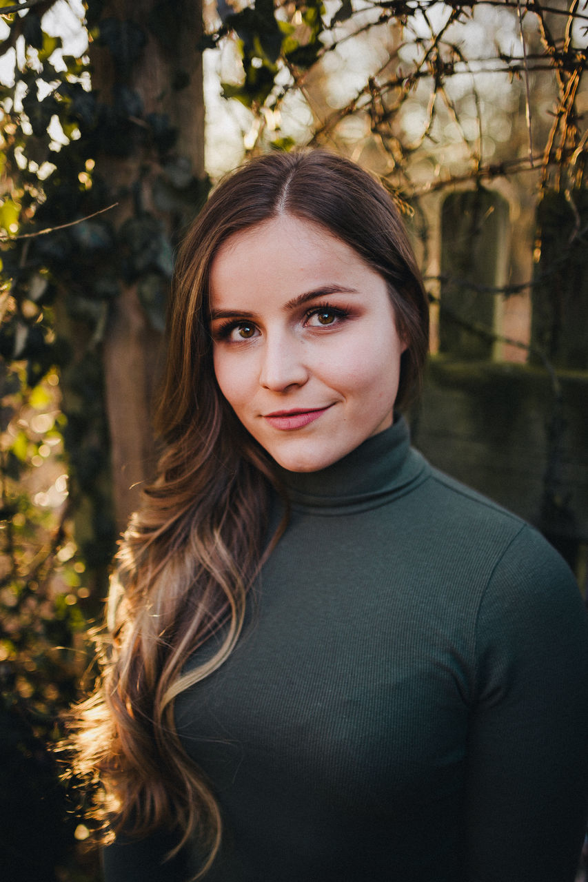 portrait, real people, long hair, looking at camera, one person, young adult, young women, leisure activity, hairstyle, lifestyles, focus on foreground, hair, front view, tree, beauty, beautiful woman, headshot, women, plant, outdoors