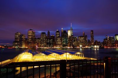 Illuminated cityscape against sky at night