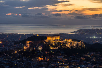 Illuminated cityscape against sky during sunset