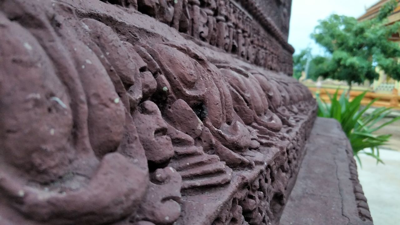 CLOSE-UP OF STATUE AGAINST BLURRED BACKGROUND