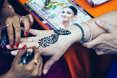 Midsection of woman with tattoo on hand