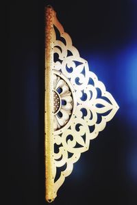 Low angle view of illuminated lamp against black background