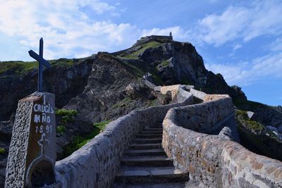 Steps leading towards mountain against sky