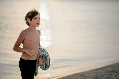 Portrait of shirtless man standing at beach