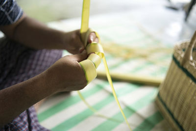 Weaving the coconut leaves making the ketupat, a traditional malay cuisine for the eid celebration.