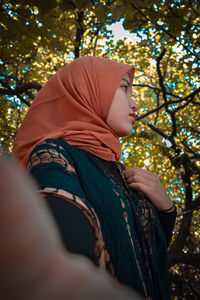 Low angle view of woman looking at tree