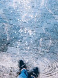 Low section of person standing on snow